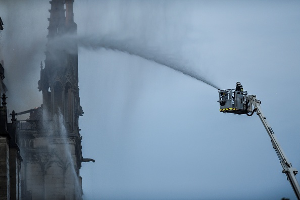 Un pompier arrose la façade de la cathédrale Notre-Dame de Paris alors que des flammes engloutissent le toit de la cathédrale le 15 avril 2019, à Paris.   (Photo : STEPHANE DE SAKUTIN/AFP/Getty Images)