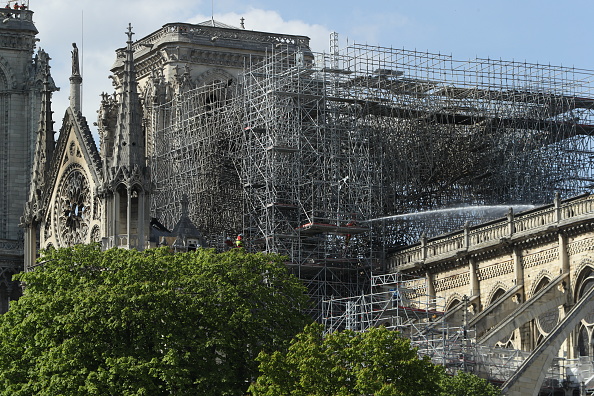 -Un pompier arrose une section de la cathédrale Notre-Dame à la suite d'un incendie majeur lundi 17 avril 2019 à Paris, en France.  La cause en est inconnue, mais des responsables ont déclaré que cela pourrait être lié aux travaux de rénovation en cours. Photo de Dan Kitwood / Getty Images.