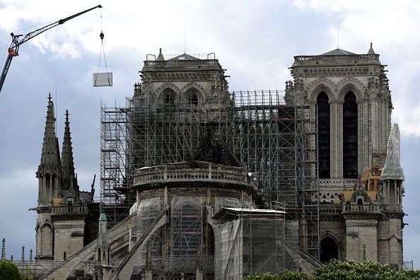 Une grue soulève un panneau dans le cadre des travaux de reconstruction de la cathédrale Notre Dame de Paris le 26 avril 2019, après que le monument ait été gravement endommagé par un énorme incendie le 15 avril dernier.  (Photo : BERTRAND GUAY/AFP/Getty Images)