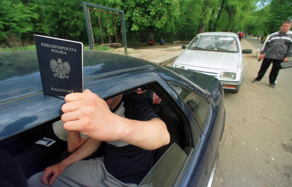 -Un homme montre son passeport, alors qu'il attend le point de contrôle de Mamonovo à la frontière russo-polonaise, près de la ville russe de Kaliningrad. Photo STRINGER / AFP / Getty Images.
