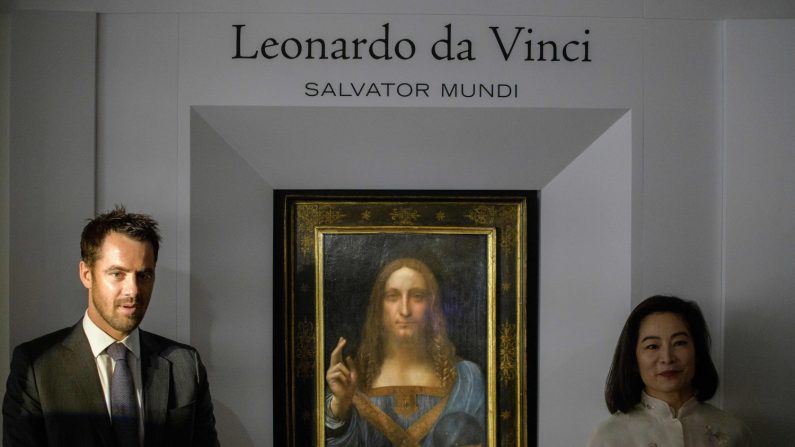 -Les représentants de Christie's posent après le dévoilement du tableau 'Salvator Mundi' de Leonardo da Vinci à Hong Kong le 13 octobre 2017. Photo ANTHONY WALLACE / AFP / Getty Images.