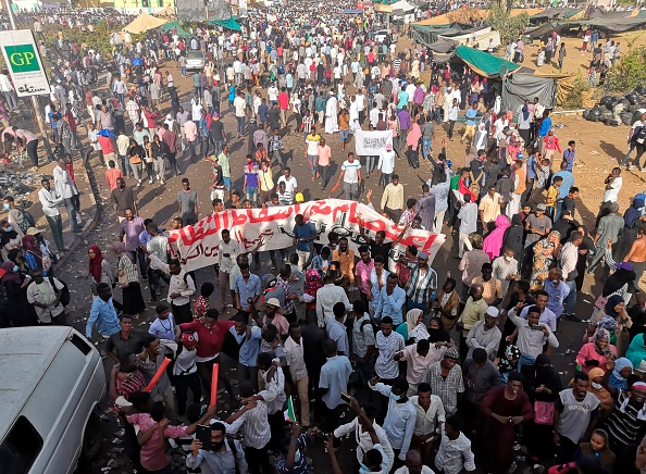 -Des manifestants soudanais se rassemblent sous un passage piéton avec une banderole portant l'inscription « Sit-in jusqu'à la chute du régime » en arabe. La police soudanaise le 9 avril a ordonné à ses forces d'éviter d'intervenir contre les manifestants alors que trois pays occidentaux mettaient tout en œuvre pour soutenir les revendications des manifestants en faveur d'un plan de transition politique dans le pays. Photo by - / AFP / Getty Images.