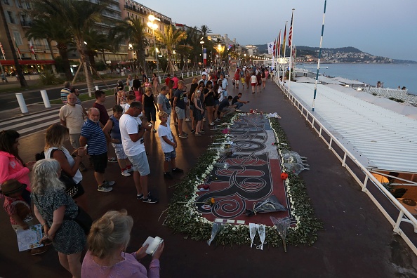 Les gens se rassemblent autour d'un mémorial de fortune le 14 juillet 2017 sur la "Promenade des Anglais" à Nice, dans le sud de la France, après une cérémonie commémorative marquant le premier anniversaire de l'attaque d'un camion djihadiste qui a tué 86 personnes le 14 juillet 2016. (Photo : VALERY HACHE/AFP/Getty Images)