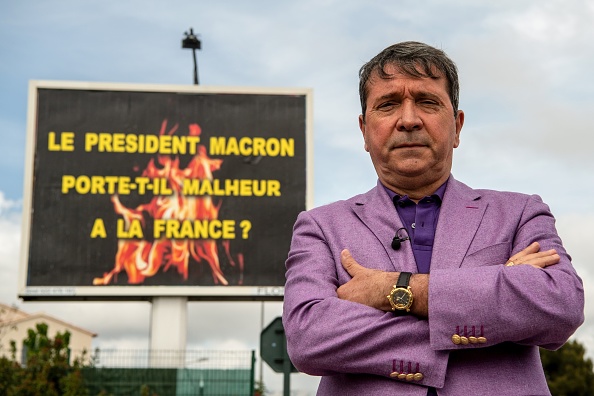 Michel-Ange Flori pose devant une de ses affiches publicitaires le 25 avril 2019 à la Seyne-sur-Mer (Var). Crédit : CHRISTOPHE SIMON/AFP/Getty Images.