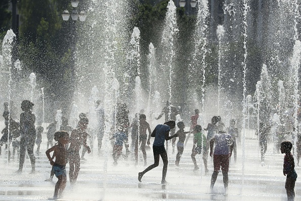 -Les gens se reposent dans une fontaine à Nice, alors qu'une vague de chaleur déferle sur l'Europe du Nord. Photo de VALERY HACHE / AFP / Getty Images.