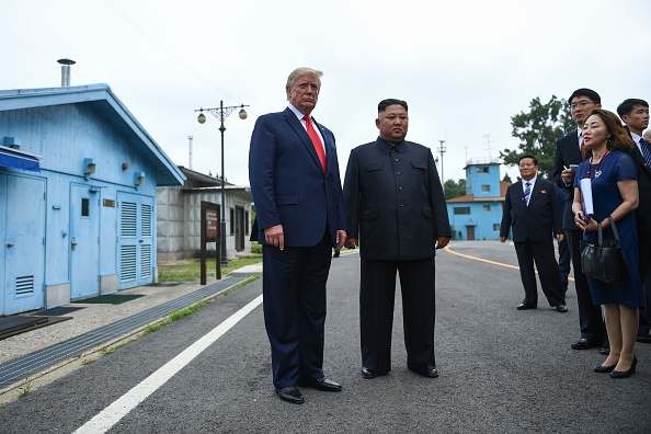 Donald Trump, aux côtés de Kim Jong Un, a franchi la limite qui marque la séparation entre les deux Corées dans le village de Panmunjom, où a été signé l'armistice de 1953 le 30 juin 2019. (BRENDAN SMIALOWSKI/AFP/Getty Images)
