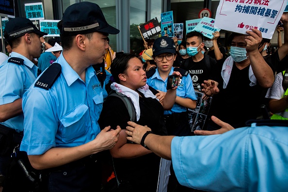 -La police retient un manifestant anti-extradition lors d'un rassemblement de soutien devant le Conseil législatif à Hong Kong le 30 juin 2019. Des milliers de personnes ont manifesté devant le parlement de Hong Kong le 30 juin, cette fois pour soutenir la police face à la critique montante sur leur utilisation de gaz lacrymogène et de balles en caoutchouc. Photo ISAAC LAWRENCE / AFP / Getty Images.