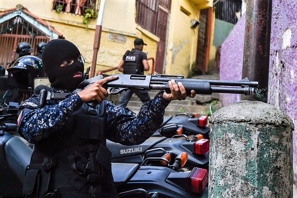 -Un membre du groupe des forces spéciales de la police nationale bolivarienne (FAES) prend position au cours d'une opération contre des groupes criminels dans le quartier de Petare à Caracas, le 25 janvier 2019. Photo de Luis ROBAYO / AFP / Getty Images.
