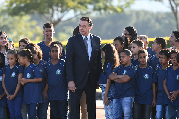 -Le 21 mai 2019, le président brésilien Jair Bolsonaro pose avec des enfants lors de la cérémonie de levée du drapeau brésilien au palais Alvorada à Brasilia. Photo EVARISTO SA / AFP / Getty Images.