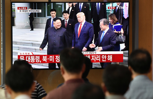 -Des gens regardent un écran d'actualités télévisé montrant des images en direct du président américain Donald Trump, du Sud-coréen Moon Jae-in et du dirigeant nord-coréen Kim Jong Un en réunion dans le village de Panmunjom dans la DMZ, dans une gare ferroviaire de Séoul le 30 juin 2019 Photo de Jung Yeon-je / AFP / Getty Images.