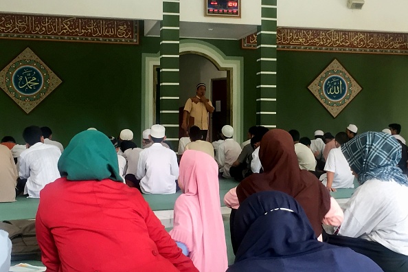 -Cette photo prise le 10 mai 2019 montre des enfants, dont les parents étaient des kamikazes ou des personnes directement impliquées dans des complots terroristes, qui assistent à une cérémonie religieuse pendant le mois sacré du ramadan, dans une mosquée située dans un lieu sûr à Jakarta. Photo de Kiki Siregar / AFP/ Getty images.