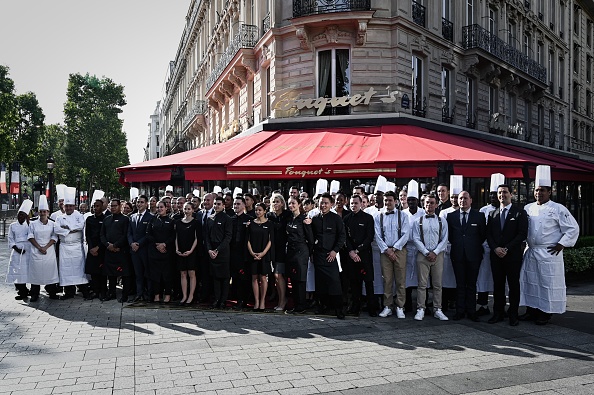 -Les employés du restaurant Le Fouquet's posent devant la brasserie à la veille de sa réouverture à Paris le 13 juillet 2019. Le légendaire restaurant parisien Le Fouquet's ouvrira ses portes le 14 juillet 2019 pour la première fois depuis que les manifestants du "gilet jaune " l’ont incendié. Photo de Philippe LOPEZ / AFP / Getty Images.
