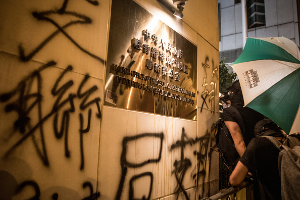 -Les manifestants pulvérisent des graffitis sur les murs du bureau de liaison du gouvernement chinois à Hong Kong après avoir participé à une marche anti-extradition le 21 juillet 2019 à Hong Kong, en Chine. Photo par Chris McGrath / Getty Images.
