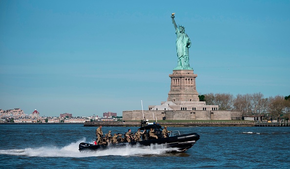 -Un bateau de la Garde côtière américaine passe devant la Statue de la Liberté lors du défilé de la Semaine de la flotte, le 22 mai 2019, à New York. Photo de Johannes EISELE / AFP / Getty Images.