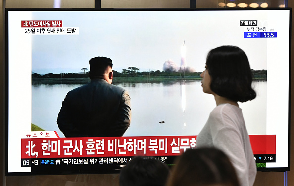Une femme passe devant un écran de télévision qui diffuse des images du dirigeant nord-coréen Kim Jong Un en train de regarder un lancement de missile dans une gare de Séoul le 31 juillet 2019. (Photo : JUNG YEON-JE/AFP/Getty Images)