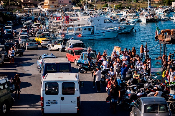 27 mineurs non accompagnés quittent le port de Lampedusa dans des fourgons de police après avoir été évacués du navire de sauvetage d'une ONG espagnole, Open Arms, amarré au large de la côte de l'île, le 17 août 2019. (Photo : ALESSANDRO SERRANO/AFP/Getty Images)