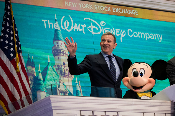 -Bob Iger et Mickey Mouse, président-directeur général de Walt Disney Compagnie, attendent avant de sonner la cloche d'ouverture à la Bourse de New York (NYSE), le 27 novembre 2017. Disney célébrait son 60e anniversaire. Photo Drew Angerer / Getty Images.