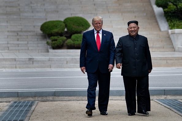 -Le président américain Donald Trump et le chef de la Corée du Nord Kim Jong-un marchent sur le sol nord-coréen en direction de la Corée du Sud dans la zone démilitarisée (DMZ) le 30 juin 2019 à Panmunjom en Corée. Photo par Brendan Smialowski / AFP / Getty Images.