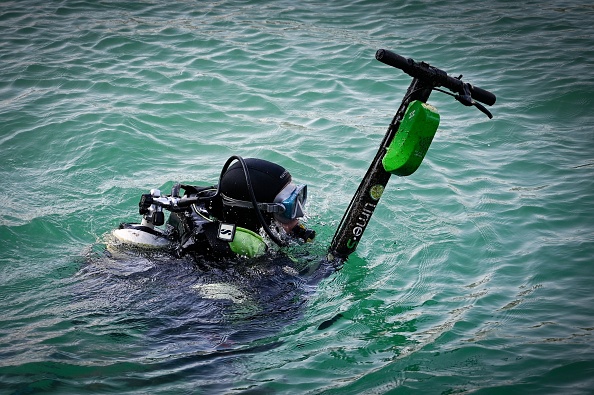 Un plongeur remonte une trottinette électrique jetée dans le Rhône. (Photo :  JULIEN/AFP/Getty Images)