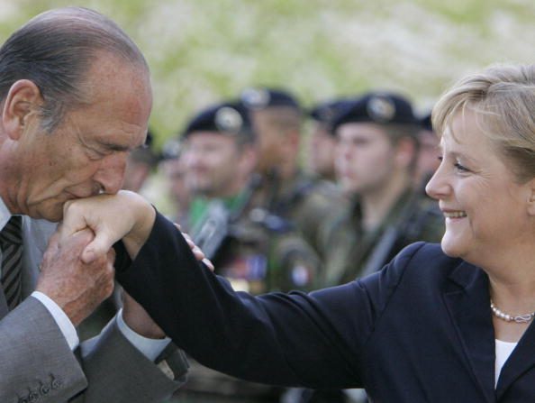 -Le président français Jacques Chirac embrasse la main de la chancelière allemande Angela Merkel à son arrivée à la Chancellerie le 3 mai 2007 à Berlin, en Allemagne. Chirac en est à son dernier voyage en Allemagne en tant que président français. Derrière les deux dirigeants se trouve une brigade militaire mixte franco-allemande. Photo de Sean Gallup / Getty Images.