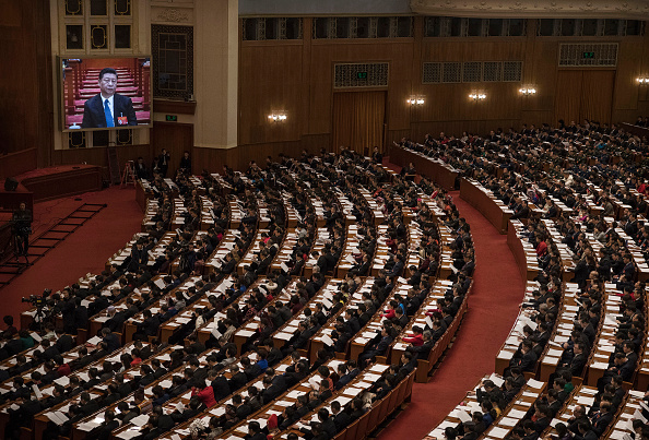 -Illustration- Le président chinois Xi Jinping est vu sur un écran pendant que les délégués regardent pendant la troisième session plénière de l'Assemblée populaire nationale à la grande salle du peuple 2019 à Beijing, en Chine. Photo de Kevin Frayer / Getty Images.