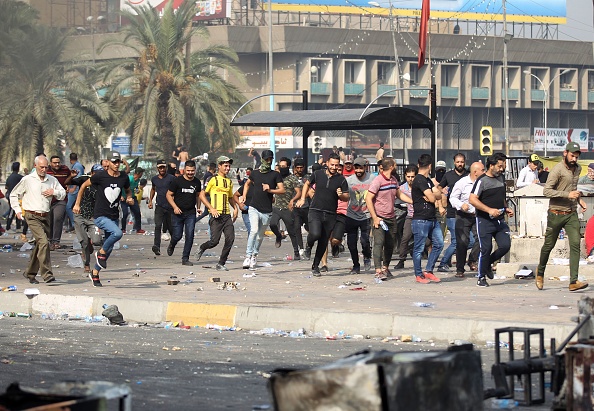 -Des manifestants fuient la police anti-émeute tirant des grenades lacrymogènes et des balles réelles lors d'affrontements entre manifestants contre la corruption de l'État, le dysfonctionnement des services publics et le chômage, sur la place Tahrir, dans la capitale irakienne, à Bagdad, le 3 octobre 2019. Les manifestations chaotiques et les affrontements qui ont suivi avec la police anti-émeute à Bagdad et dans plusieurs villes du sud du pays ont fait plus d'une douzaine de manifestants et un policier tué. Photo par AHMAD AL-RUBAYE / AFP / Getty Images.