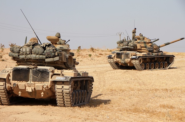 -Des soldats turcs conduisent des chars américains M60 dans la ville de Tukhar, au nord de la ville de Manbij, dans le nord de la Syrie, le 14 octobre 2019. Les forces du régime syrien se sont dirigées vers la frontière turque après l’accord entre Damas et les forces kurdes assiégées à la suite d'une annonce du retrait américain. Photo par AREF TAMMAWI / AFP / Getty Images.