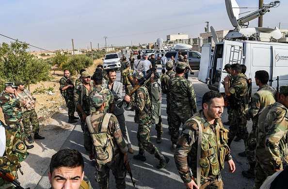 -Les forces gouvernementales syriennes passent devant les véhicules de l’équipe médiatique à la périphérie de la ville nord de Manbij, dans le nord de la province d’Alep, les forces gouvernementales y sont déployées le 15 octobre 2019. Image de - / AFP via Getty Images.