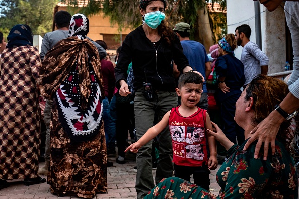 -Une femme et un enfant réagissent lorsque le corps d'un homme tué lors d'un bombardement par des Turcs dans les environs de la ville kurde syrienne de Ras al-Ain arrive à l’hôpital à la suite du cessez-le-feu annoncé le 18 octobre 2019. L’accord négocié par les États-Unis, vieux de plusieurs heures, semblait déjà s'effondrer. Cet accord devait permettre une pause de cinq jours pour l'évacuation des combattants kurdes de la ville frontalière du champ de bataille de Ras al-Ain et d'autres zones que la Turquie souhaitait contrôler le long de sa frontière avec la Syrie. Photo de DELIL SOULEIMAN / AFP via Getty Images.