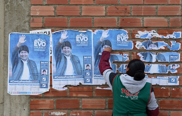 Une femme enlève des affiches d'Evo Morales de Bolivie du mur d'une maison à El Alto le 11 novembre 2019, un jour après la démission du dirigeant de gauche à la présidence.(Photo : AIZAR RALDES/AFP via Getty Images)