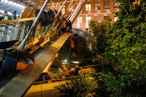 Une manifestant s'évade à l'aide d'une corde du campus de l'Université polytechnique de Hong Kong dans le district de Hung Hom à Hong Kong le 18 novembre 2019. (Photo : ANTHONY WALLACE/AFP via Getty Images)