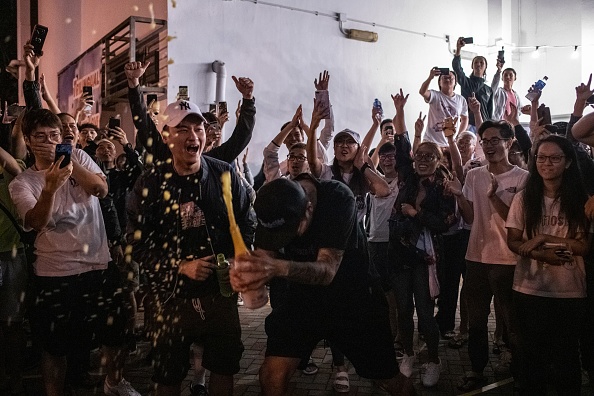 Un partisan en faveur de la démocratie célèbrent devant un bureau de vote pour célébrer le 25 novembre 2019, après la perte du siège du candidat pro-Pékin, aux élections du conseil de district du district de Tuen Mun à Hong Kong. (Photo : PHILIP FONG/AFP via Getty Images)