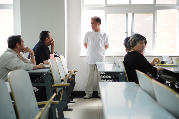 -Cette photo prise le 12 juin 2010, montre le professeur d'université, blogueur et membre de la minorité musulmane ouïghoure, Ilham Tohti il discute avec des étudiants après sa conférence dans une salle de classe à Pékin. Le Parlement européen a décerné le prix Sakharov pour les droits de l'homme à l'intellectuel ouïghour Ilham Tohti, condamné à la prison à perpétuité en Chine pour "séparatisme", au risque de hérisser Pékin. Photo par FREDERIC J. BROWN / AFP via Getty Images.