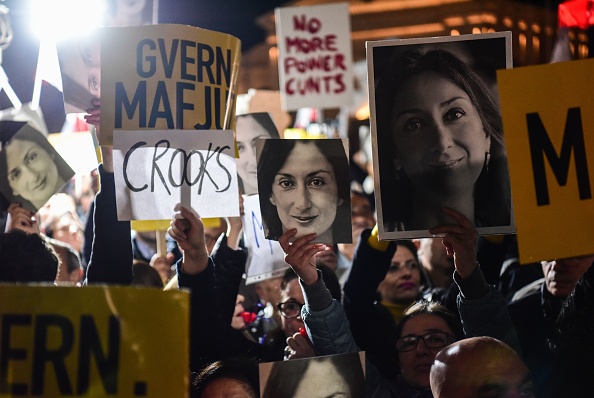 Des personnes portant des pancartes sur lesquelles figurent "le gouvernement de la mafia" et les photos de la journaliste assassinée Daphne Caruana Galizia, organisent une manifestation organisée par la famille et les mouvements civiques de Galizia le 29 novembre 2019 devant le bureau du Premier ministre à La Valette, à Malte. (Photo : STRINGER/AFP via Getty Images)