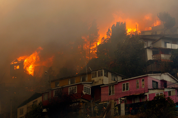 -Des maisons ont brûlé lors d'un incendie de forêt sur la colline Rocuant à Valparaiso, au Chili, le 24 décembre 2019. Une alerte rouge a été déclarée. Photo de RAUL ZAMORA / ATON CHILI / AFP via Getty Images.