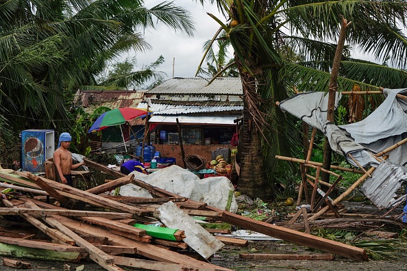 -Un résident regarde une maison endommagée par le typhon Phanfone à Tacloban, dans le centre des Philippines, le 25 décembre 2019. Photo de BOBBIE ALOTA / AFP via Getty Images.