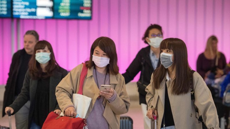  Les passagers portent des masques de protection contre la propagation du coronavirus à leur arrivée à l'aéroport international de Los Angeles, en Californie, le 22 janvier 2020. (Mark Ralston/AFP via Getty Images)