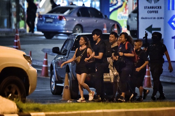 -Les gens se rassemblent à l'extérieur après avoir été secourus par des commandos thaïlandais du centre commercial Terminal 21, où une fusillade a eu lieu, le 9 février 2020 dans la ville de Nakhon Ratchasima, dans le nord-est de la Thaïlande. Photo de Lillian SUWANRUMPHA / AFP via Getty Images.
