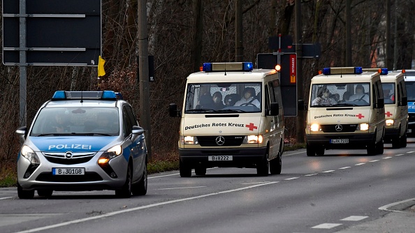 Le convoi comprenant trois minibus de la Croix-Rouge allemande transportant des citoyens allemands rapatriés de la ville chinoise touchée par le coronavirus de Wuhan arrive à l'hôpital de la Croix-Rouge allemande à Berlin Kopenick, le 9 février 2020. (Photo : JOHN MACDOUGALL/AFP via Getty Images)