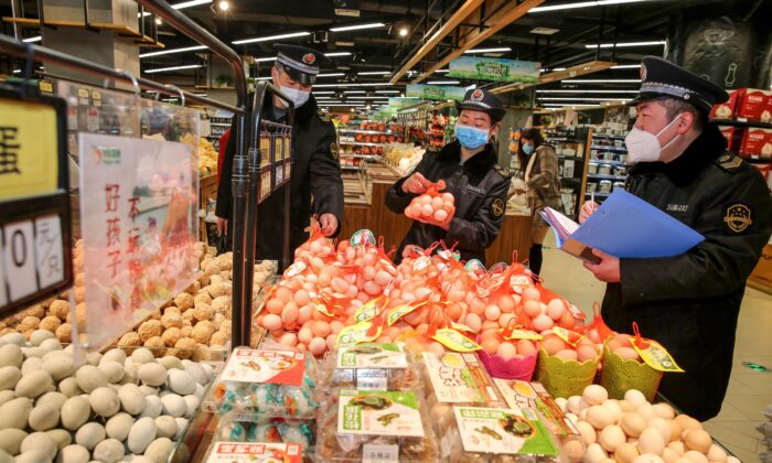 Cette photo prise le 20 février 2020 montre la surveillance du marché administrer le contrôle des œufs dans un supermarché alors qu'ils surveillent le prix des marchandises pendant l'épidémie du coronavirus de Wuhan à Huaibei dans la province orientale de l'Anhui en Chine. - Le nombre de décès en Chine dus à l'épidémie de coronavirus est passé à 2 236 le 21 février après que 118 personnes supplémentaires sont décédées, la plupart dans la province du Hubei, épicentre du pays, qui a été durement touchée, a déclaré le gouvernement. (Photo par STR / AFP) / China OUT (Photo par STR/AFP via Getty Images)
