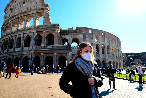 Une touriste portant un masque respiratoire protecteur visite le monument du Colisée (Coliseum, Coliseum) à Rome le 28 février 2020, dans un contexte de la peur de l'épidémie de Covid-19. (Photo : ANDREAS SOLARO/AFP via Getty Images)