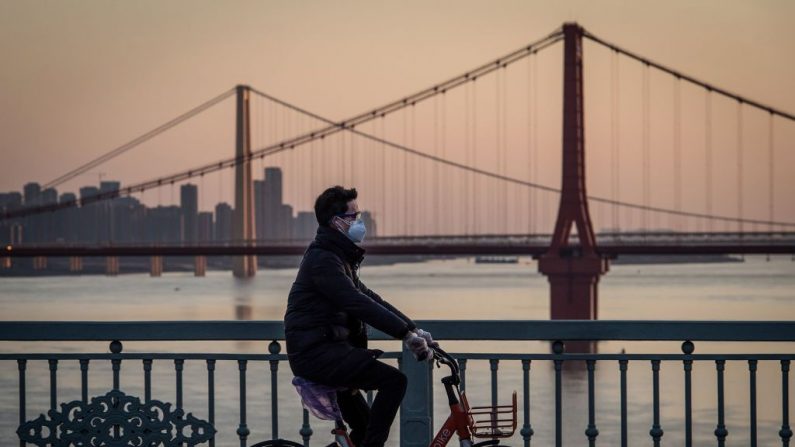 Un homme portant un masque de protection fait du vélo à Wuhan, en Chine, le 17 février 2020. (STR/AFP via Getty Images)
