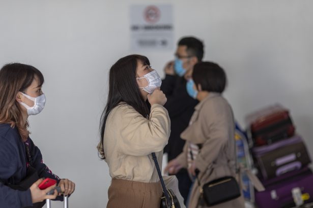 Les voyageurs arrivent au terminal international de LAX Tom Bradley en portant des masques de protection contre la nouvelle épidémie de coronavirus à Los Angeles, Californie, le 2 février 2020. (David McNew/Getty Images) 