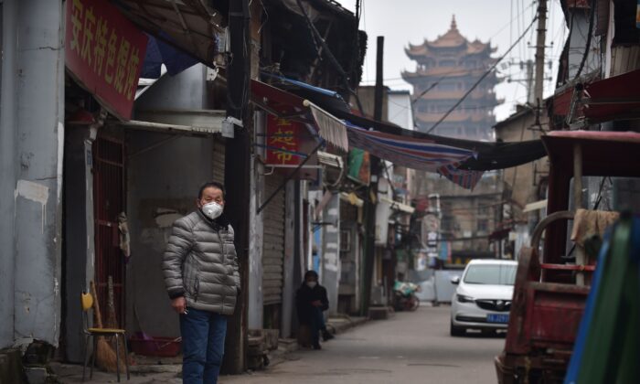 Un homme porte un masque facial à titre préventif contre le coronavirus COVID-19 dans une ruelle de Wuhan, dans la province centrale de Hubei en Chine, le 26 février 2020. (STR/AFP via Getty Images)