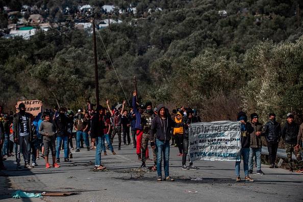 Des migrants participent à une manifestation le lundi 2 mars après des heurts avec la police gecque aux abords du camp de Moria sur l’île de Lesbos . Crédit : ANGELOS TZORTZINIS/AFP via Getty Images.