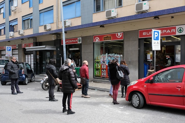 Les gens gardent une distance de sécurité dans le cadre des mesures de précaution contre la propagation du virus de Wuhan, en faisant la queue pour entrer dans un supermarché à Messine, en Sicile, le 10 mars 2020 (Photo : GIOVANNI ISOLINO/AFP via Getty Images)