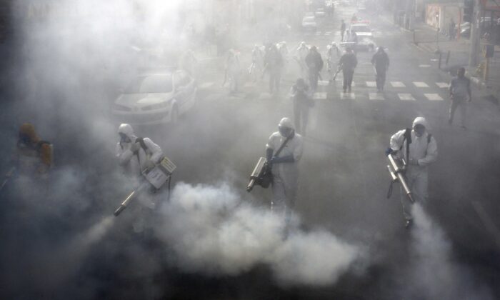 Les pompiers iraniens désinfectent les rues de la capitale Téhéran alors qu'ils essayent de maîtriser la propagation sauvage du coronavirus, le 13 mars 2020. (AFP via Getty Images)
