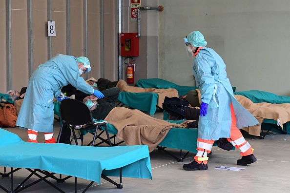Des personnels prennent soin d'un patient dans une structure temporaire installée à côté des urgences de l'hôpital de Brescia, en Lombardie, le 13 mars 2020. (MIGUEL MEDINA/AFP via Getty Images)