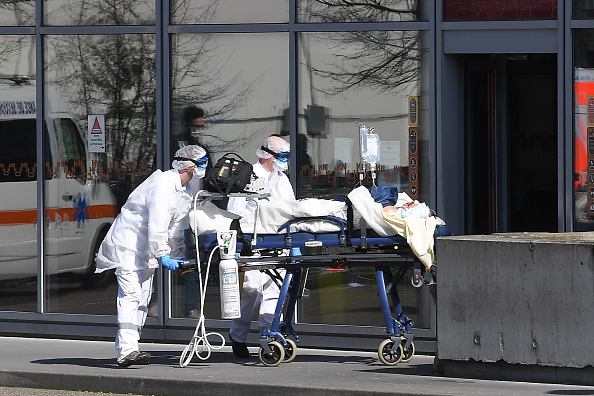 Un patient sous assistance respiratoire est escorté aux Hôpitaux universitaires de Strasbourg par des membres du personnel médical des services d'urgence du SAMU-SMUR. (Photo : PATRICK HERTZOG/AFP via Getty Images)