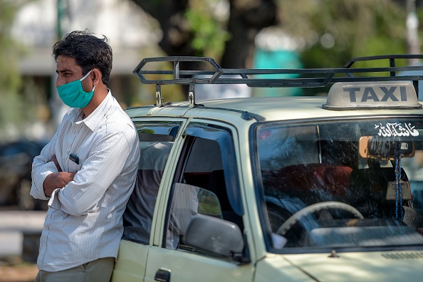 Un chauffeur de taxi portant un masque de protection contre le coronavirus COVID-19 attend un client devant un hôpital à Islamabad le 17 mars 2020. (Photo : FAROOQ NAEEM/AFP via Getty Images)